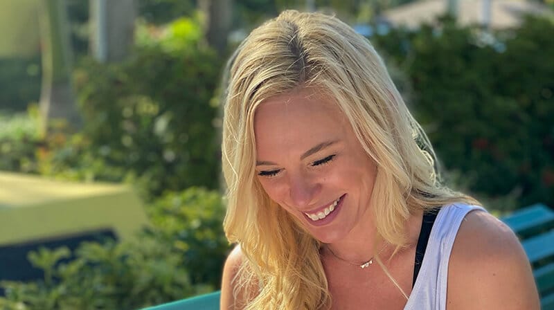 Jessie sitting on a park bench, smiling