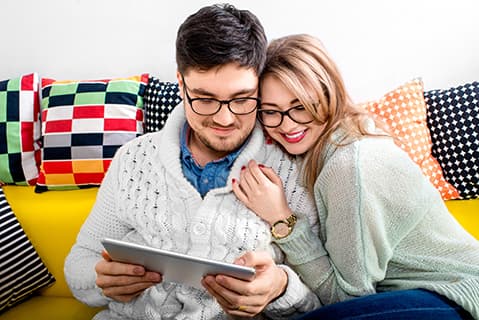 Young couple on couch with tablet