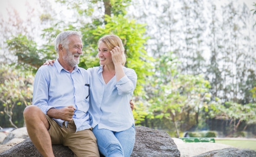 Father and daughter sitting on rock