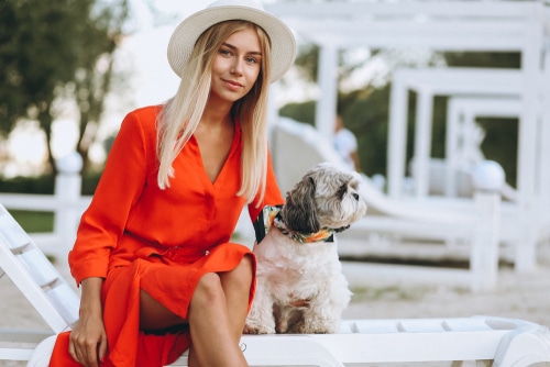 girl in dress sitting with dog