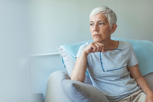 Serious woman on couch at home
