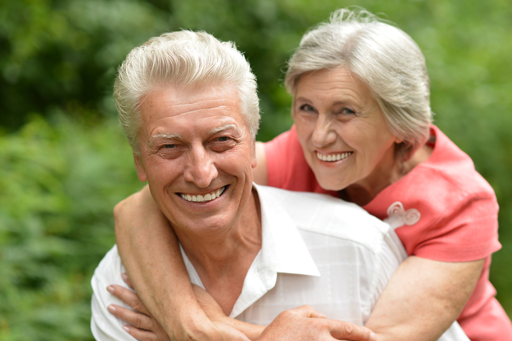 older man and woman hugging and smiling for their picture