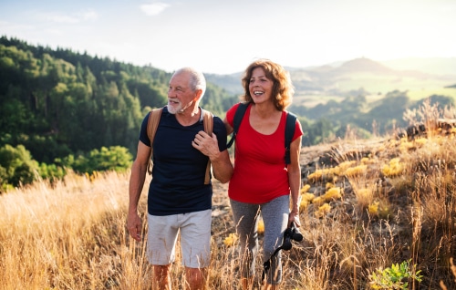 older couple hiking in woods