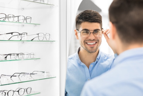 Young man trying on eyeglasses