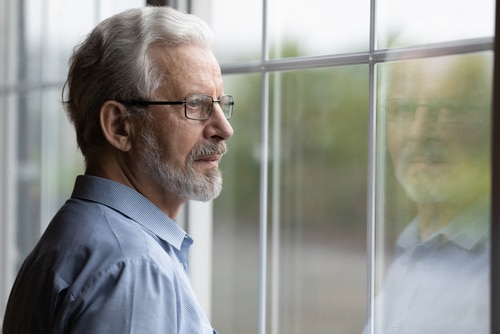 Older man looking out a window