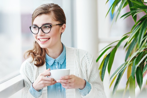 Woman with coffee by a window