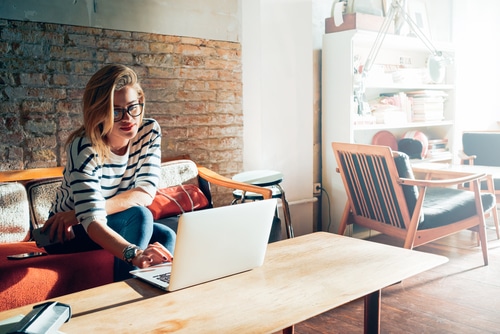 girl looking at laptop in living room