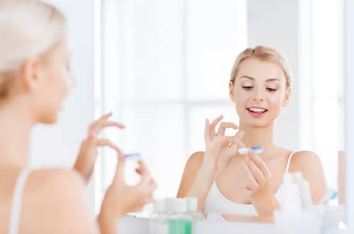 Woman putting in contact lenses 