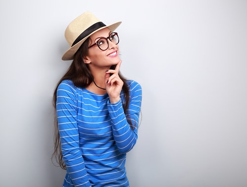 Woman with blue shirt looking up at ceiling and smiling. 