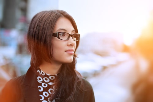 girl standing in the middle of the street looking into distance